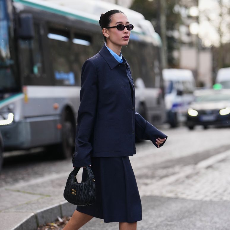 Image may contain: Maggie Q, Person, Clothing, Coat, Pedestrian, Formal Wear, Suit, Bus, Transportation, Vehicle, and Adult