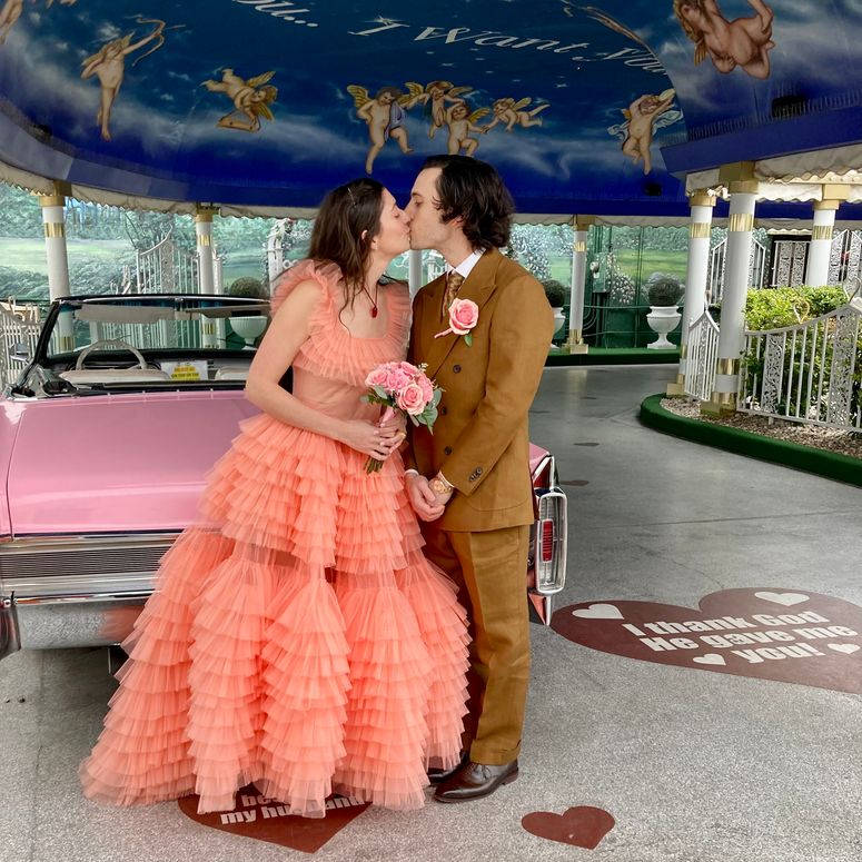 Image may contain: Clothing, Dress, Formal Wear, Kissing, Person, Romantic, Plant, Potted Plant, Fashion, Gown, and Adult