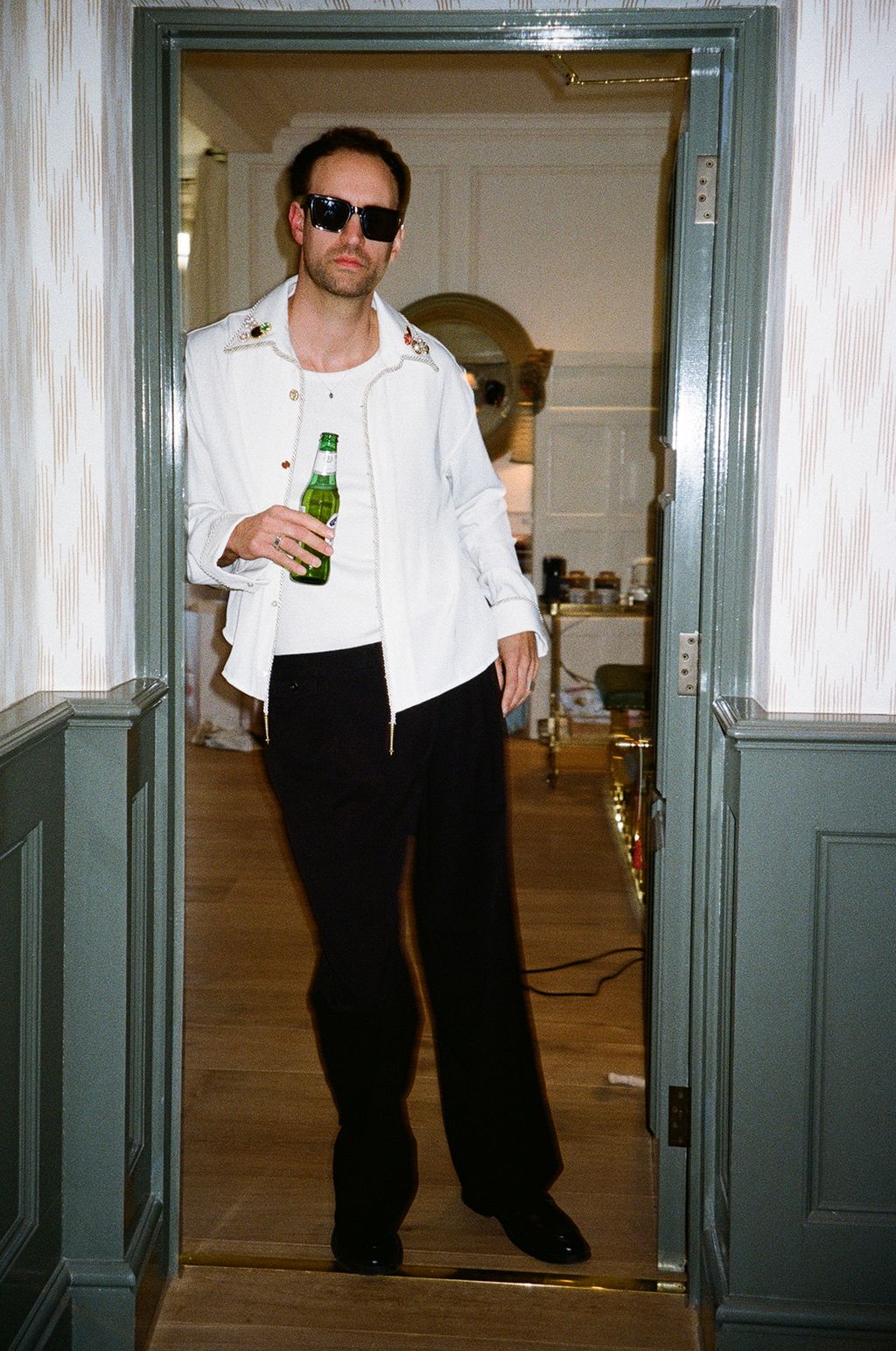 Image may contain Blazer Clothing Coat Jacket Accessories Sunglasses Pants Door Alcohol Beer Beverage and Adult